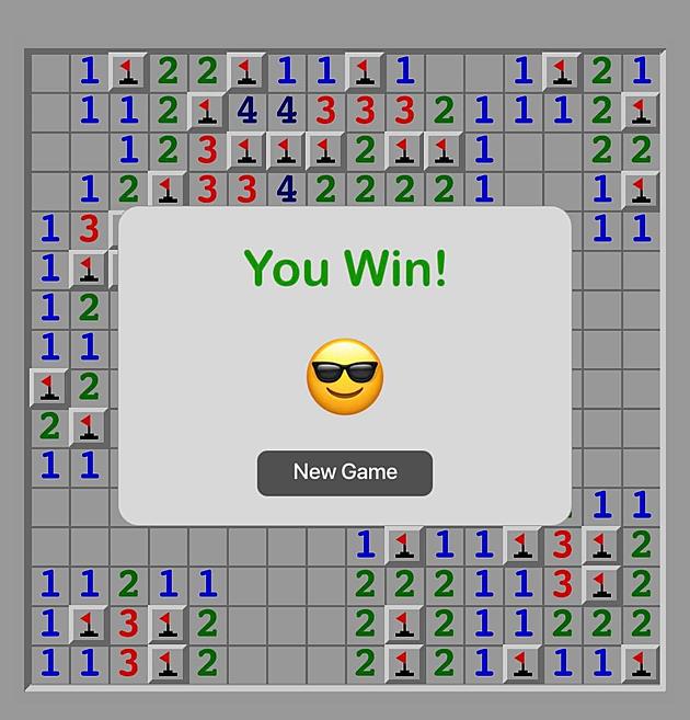 A screen shows a victorious game of Minesweeper and a smiling emoji with sunglasses on.